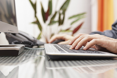 Man is typing on keyboard and using mouse