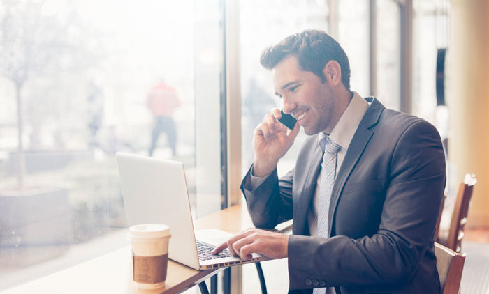 business man sitting at a cafe discussing his health options on his cell phone
