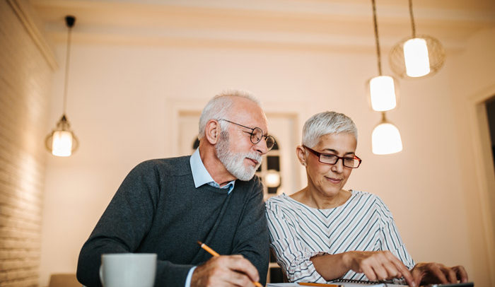elderly couple weighing their long term care options at a dining room table