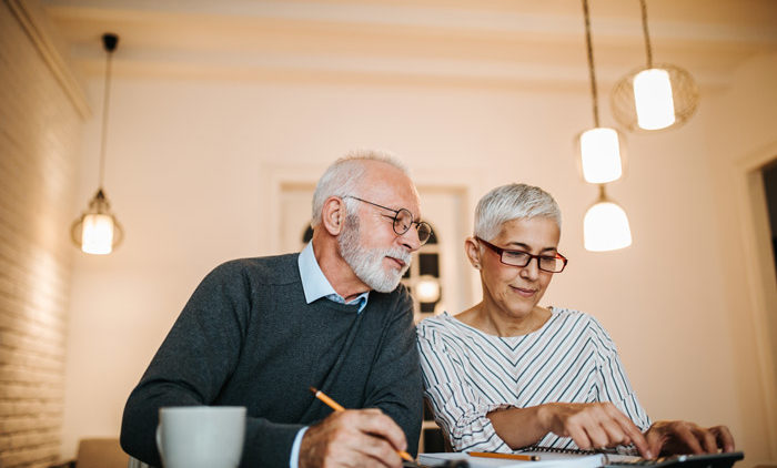 elderly couple weighing their long term care options at a dining room table